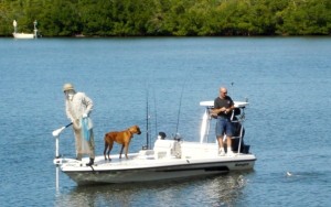 Man fishing with dog on boat