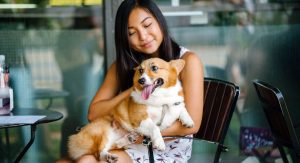 Women dining outside with dog on her lap