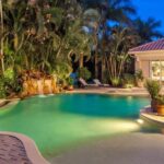Luxury vacation home at night with lit pool